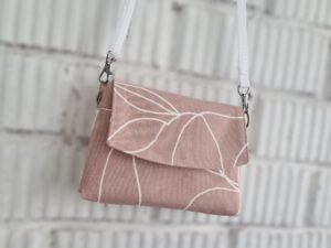 A pink purse with white strap